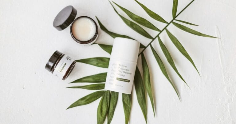 Baume et cremes cosmetiques au CBD poses sur une feuille de palmier, routine peau naturelle